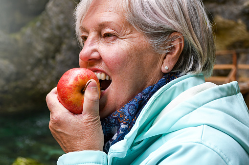 Older woman biting an apple