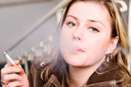 Blonde woman smoking a cigarette and blowing smoke